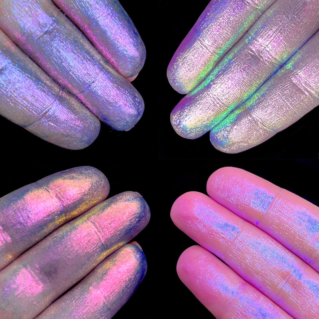 Four fingers with iridescent purple and pink pastel pigments are shown against a black background.