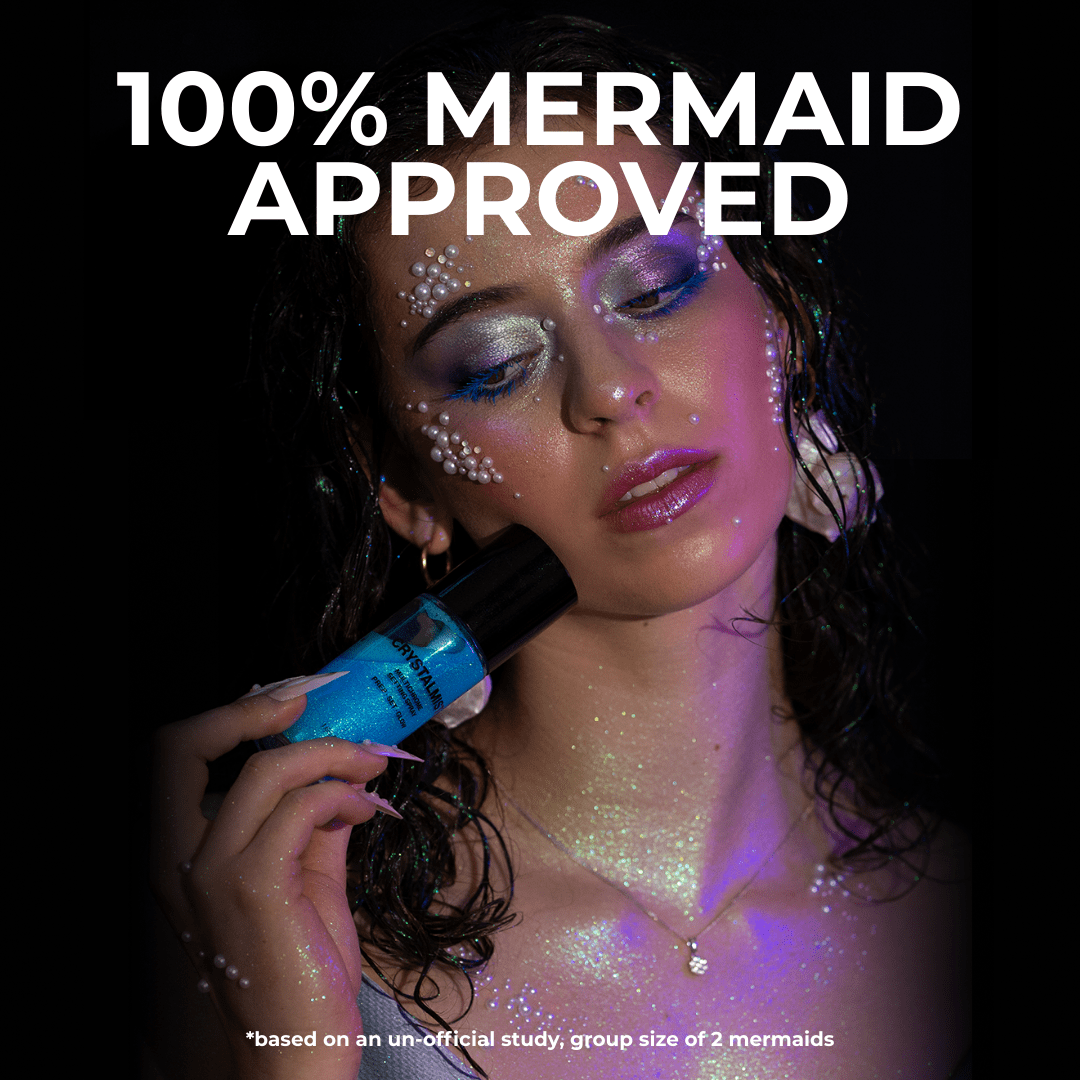 A woman with glittery blue makeup and wet hair holds up a CrystalMist Multichrome Setting Spray