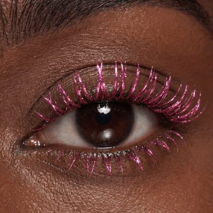 Close-up of a brown eye with magenta mascara on the lashes