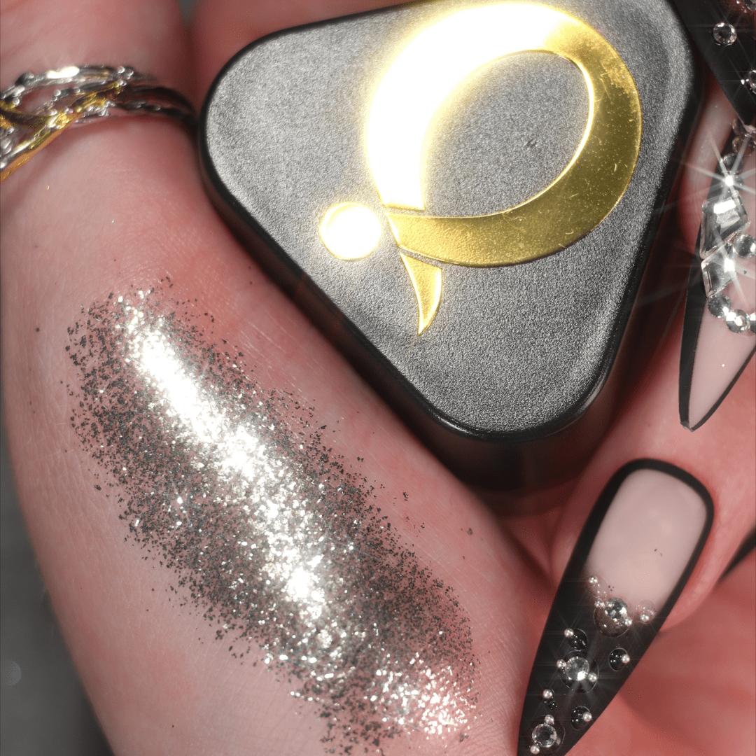 A hand is shown beside a glitter swatch and a Silver Mirror container.