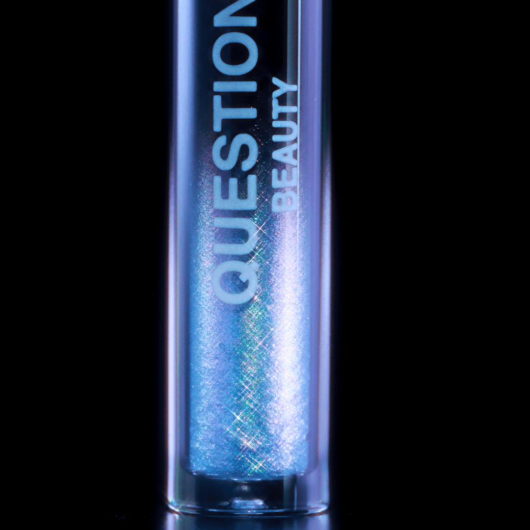 A close-up of a tube labeled Question Beauty with lilac shimmer set against a black background.