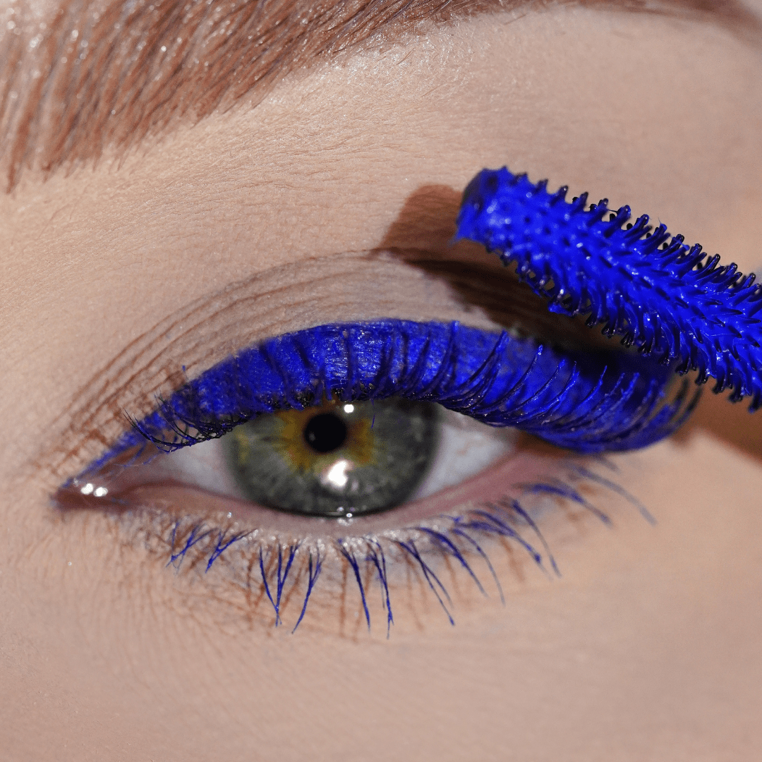 Close-up of upper lashes coated in blue mascara with matching blue eyeliner on the eyelid.