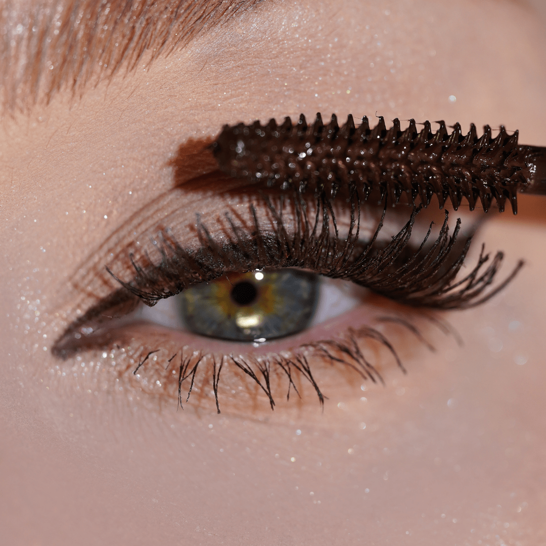 Close-up of an eye with brown mascara applied to the upper lashes for added volume.