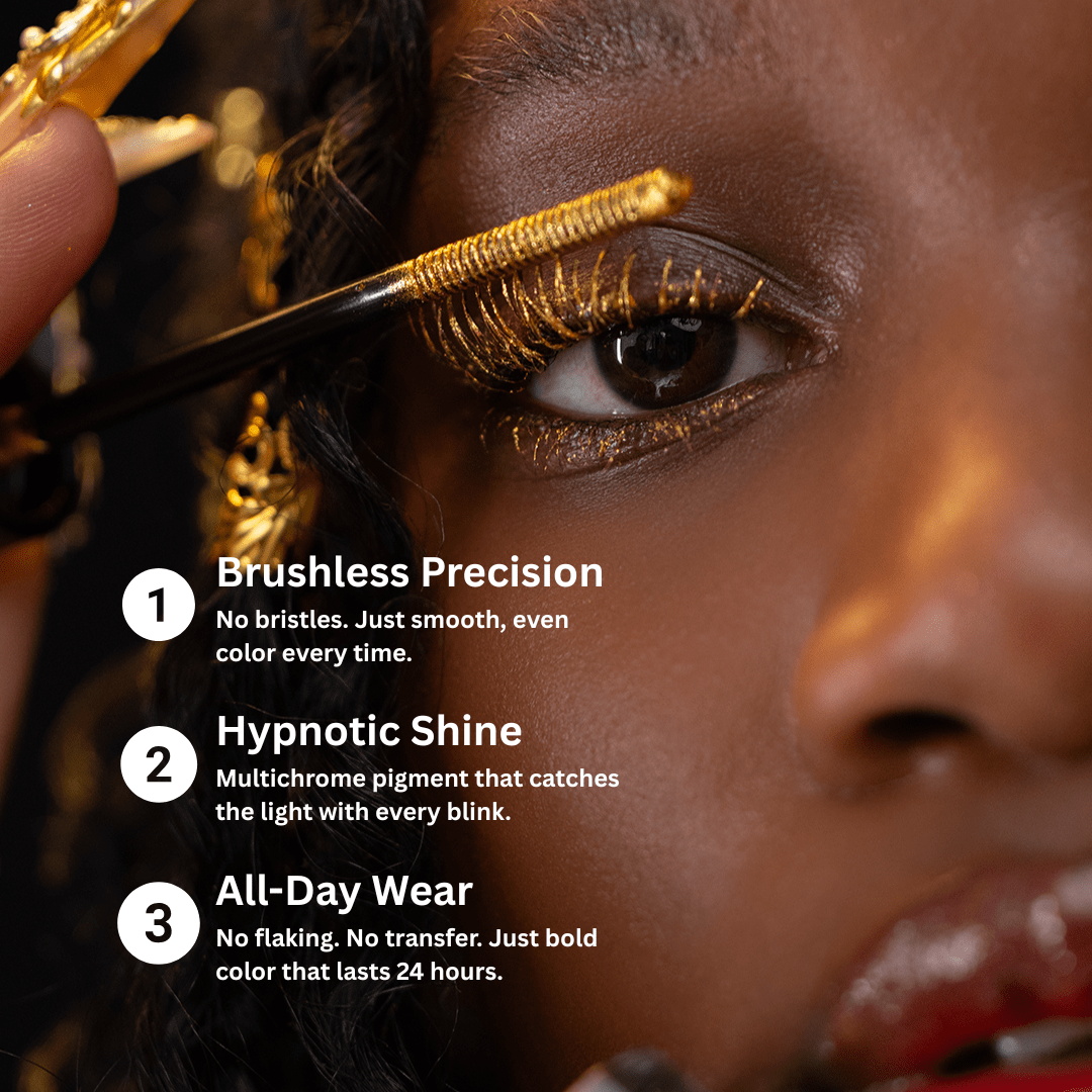 A close-up of a woman applying mascara with a small brush to her eyelashes.