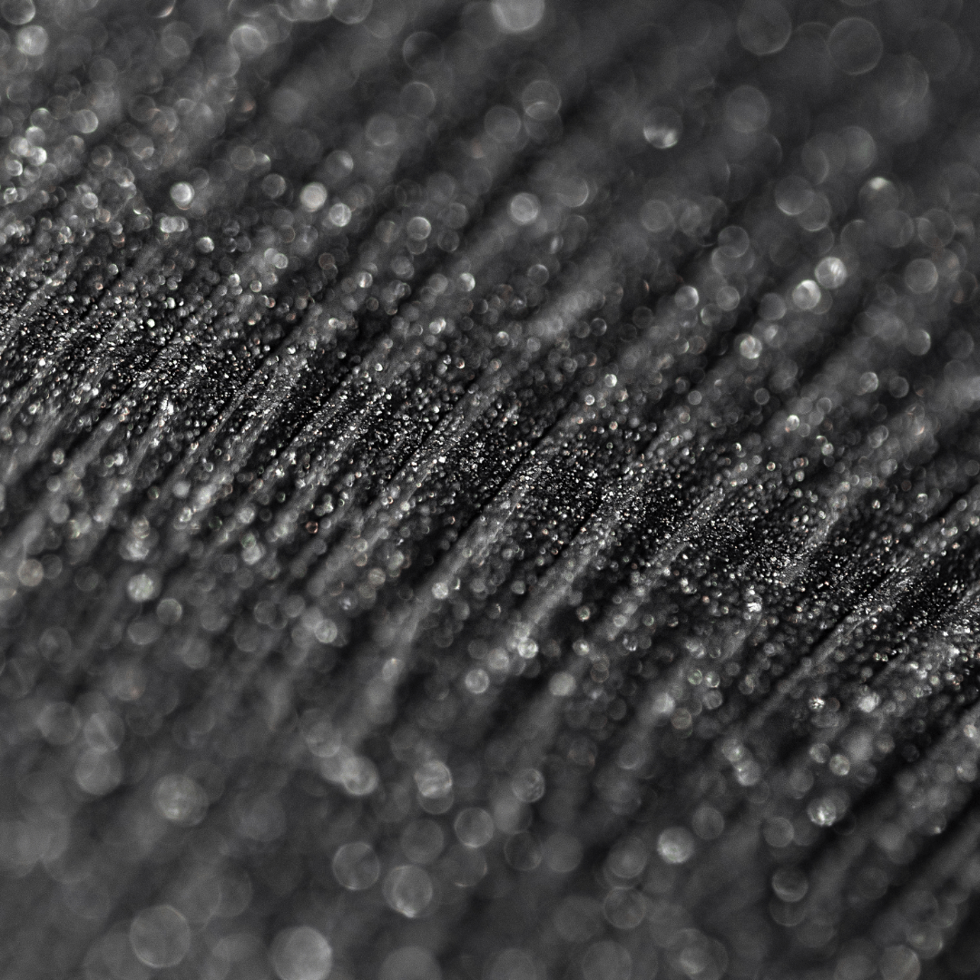 Close-up of black mascara with ridged texture and visible sparkling glitter.