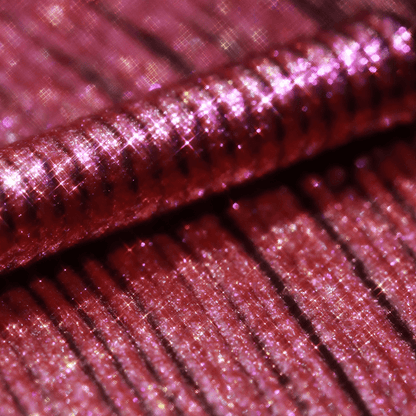 Close-up of shiny pink glitter applicator with iridescent highlights and ridges