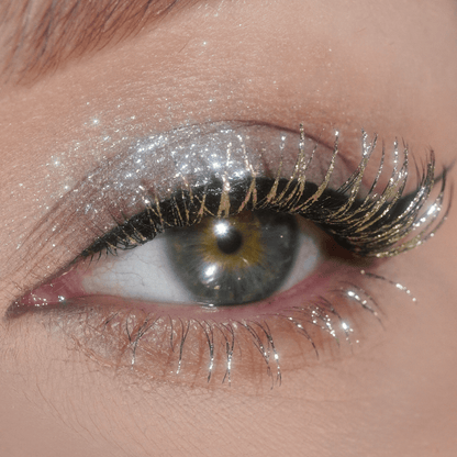 Close-up of an eye with shimmering silver eyeshadow and visible Celestial Silver Mascara Topper highlighting the lashes.