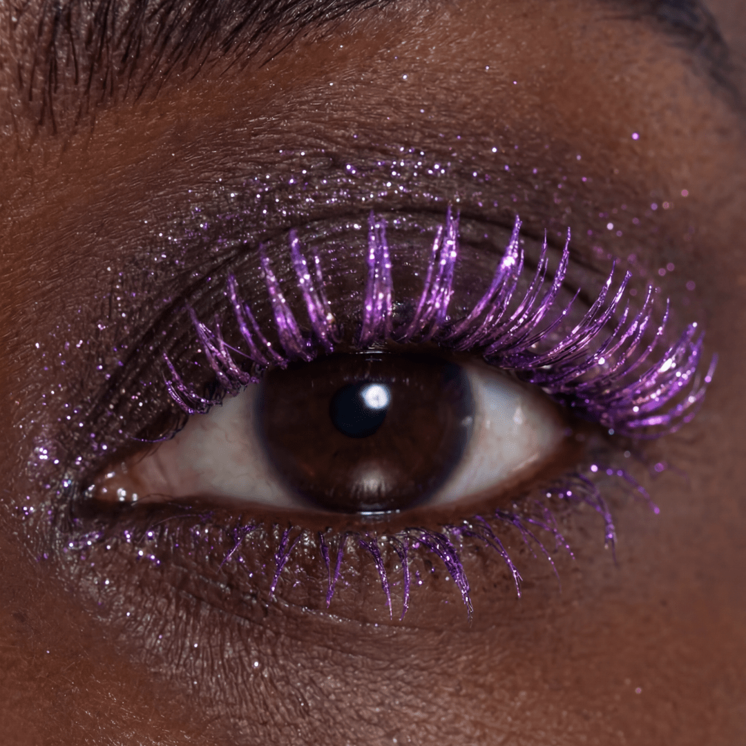Close-up of a brown eye with pink mascara and matching shimmer eyeshadow.