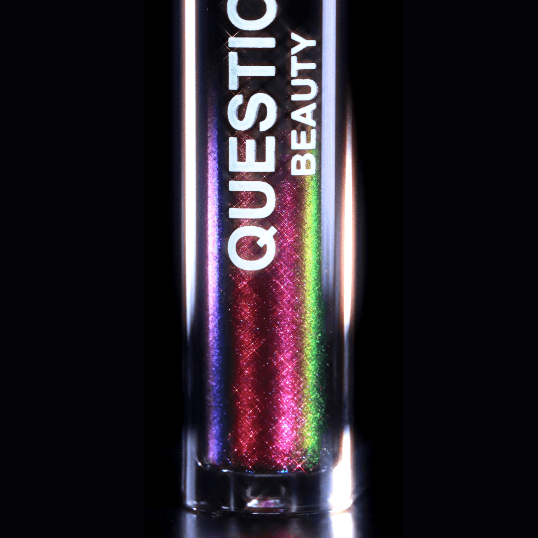 A mascara topper with iridescent red, green, and purple highlights is shown on a black background.