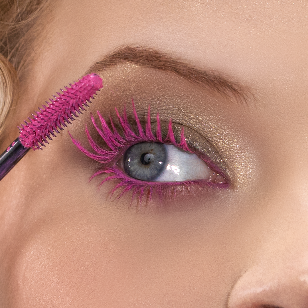 Close-up of a person applying bright pink mascara to lashes