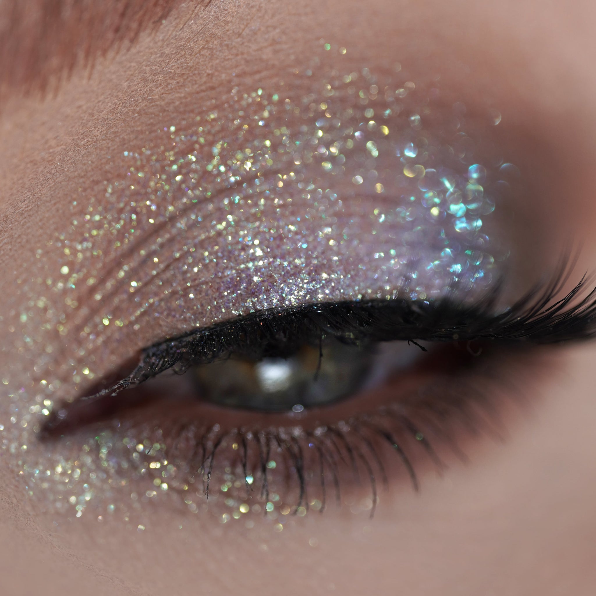 Close-up of an eye with shimmering holographic glitter eyeshadow.