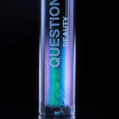 A tube labeled Question Beauty with blue, purple, and green shimmer sits against a black background.