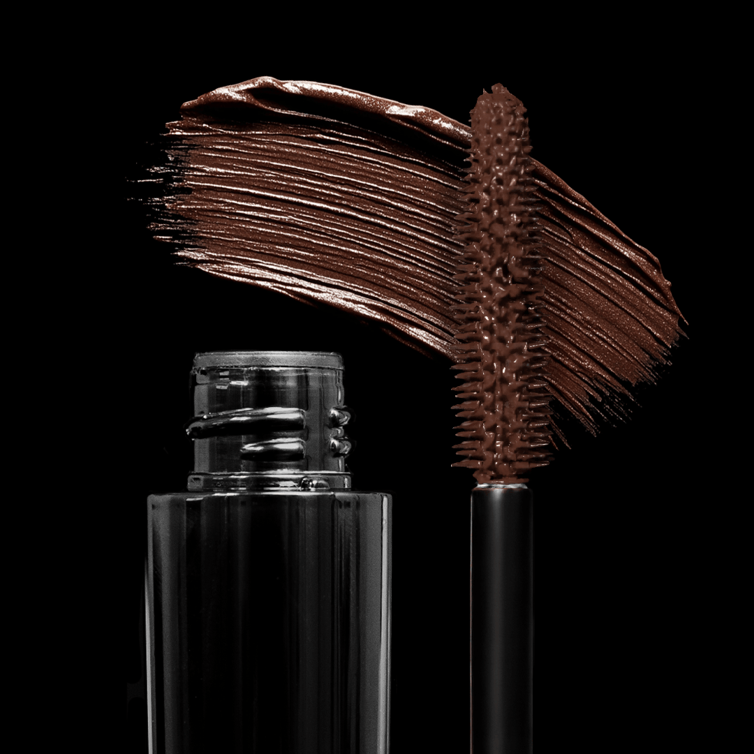 An open tube of brown mascara with a visible wand and a swipe of product on a black background.