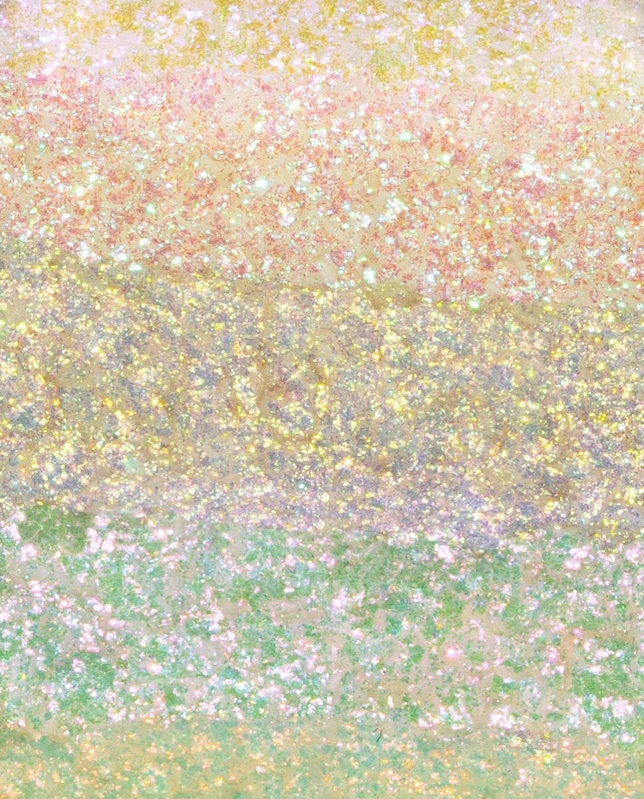 A compact highlighter palette displays a pastel rainbow shimmer with soft yellow, pink, green, and purple shades.