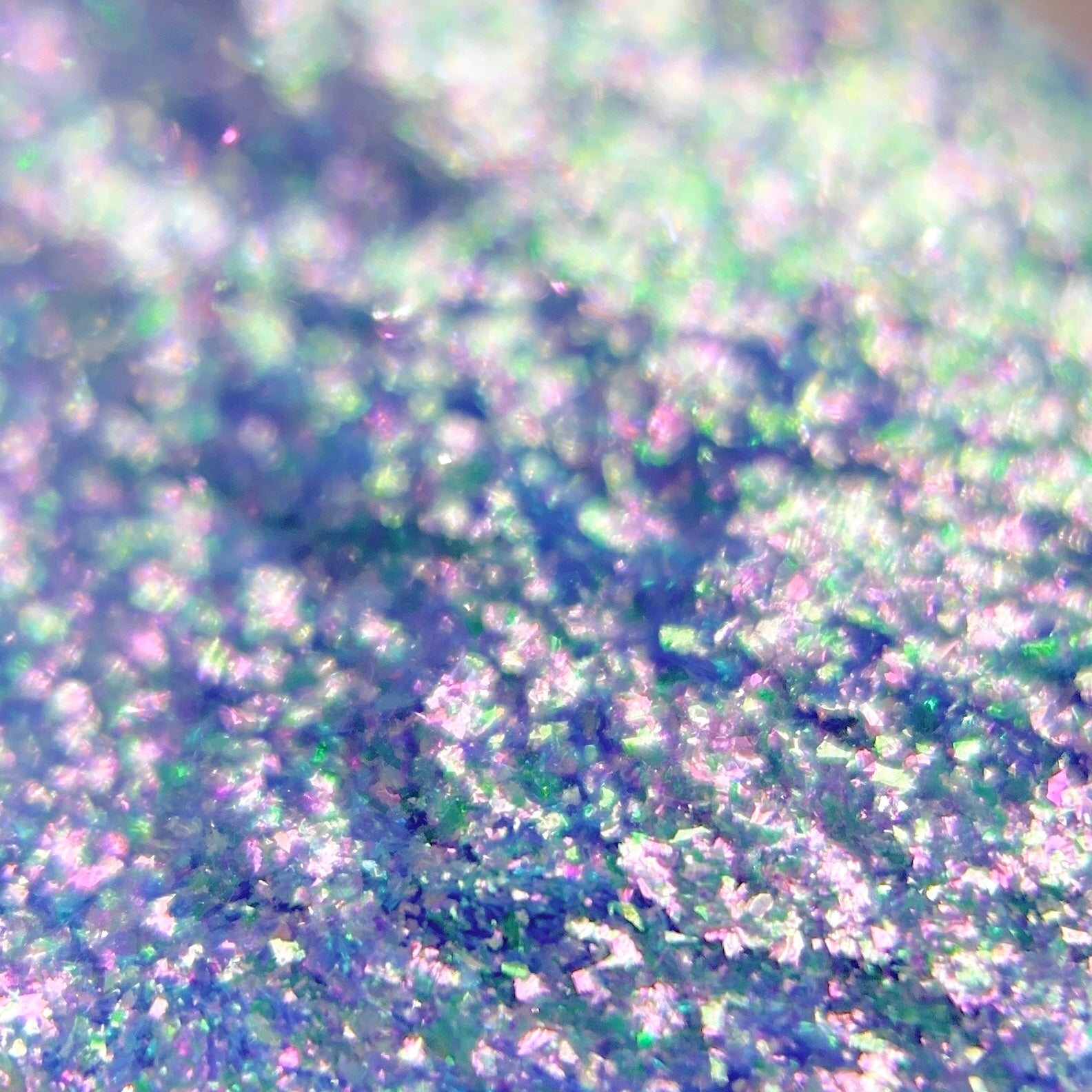 Close-up of iridescent blue glitter with holographic pink and blue highlights.