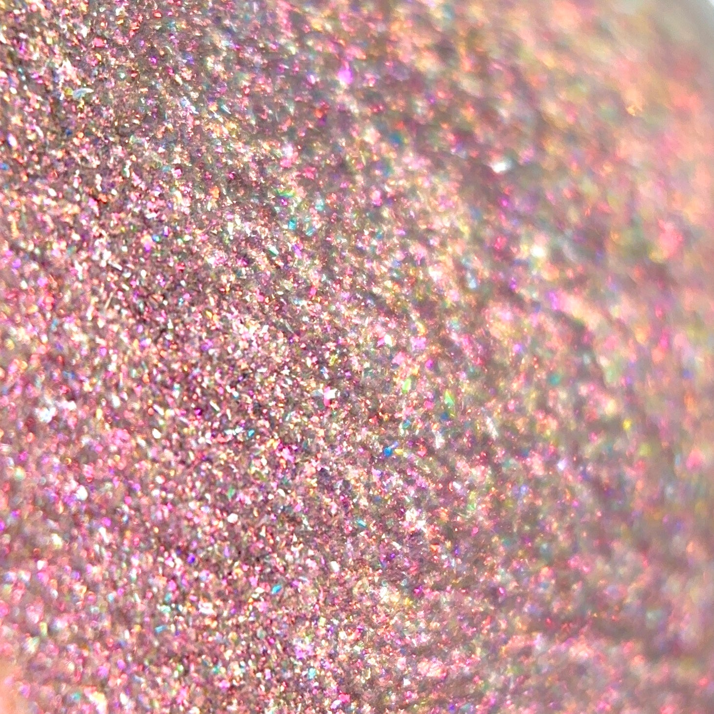 Close-up of pink glitter with visible pink and gold holographic shimmer.