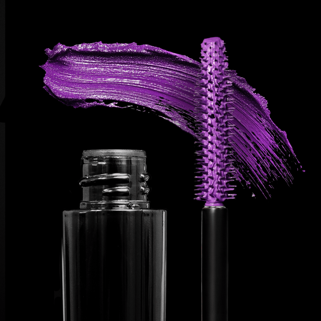 An open tube of mascara with its wand and a bright purple-colored swipe on a black background.