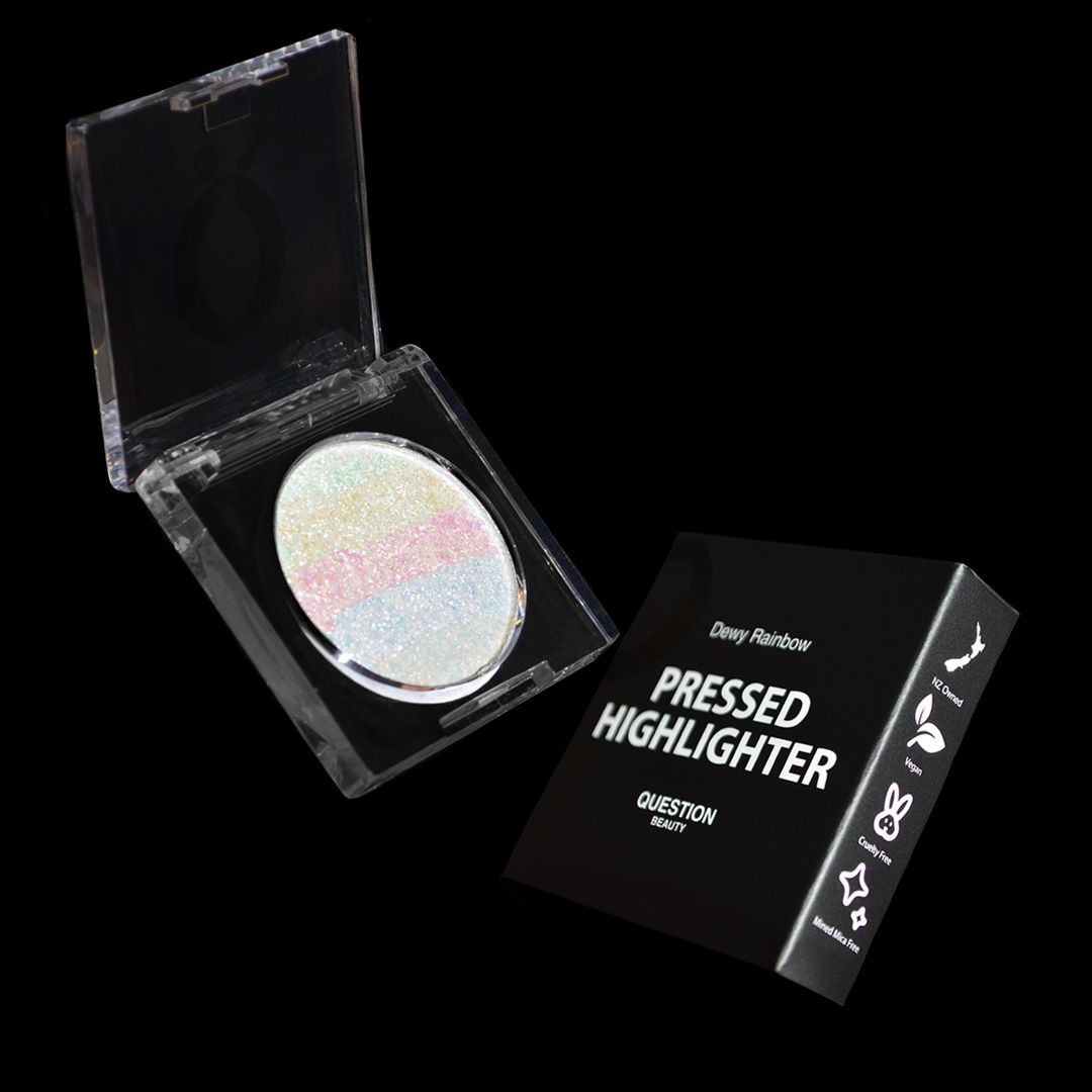 An open compact shows a highlighter with shimmery rainbow stripes next to a plain black box.